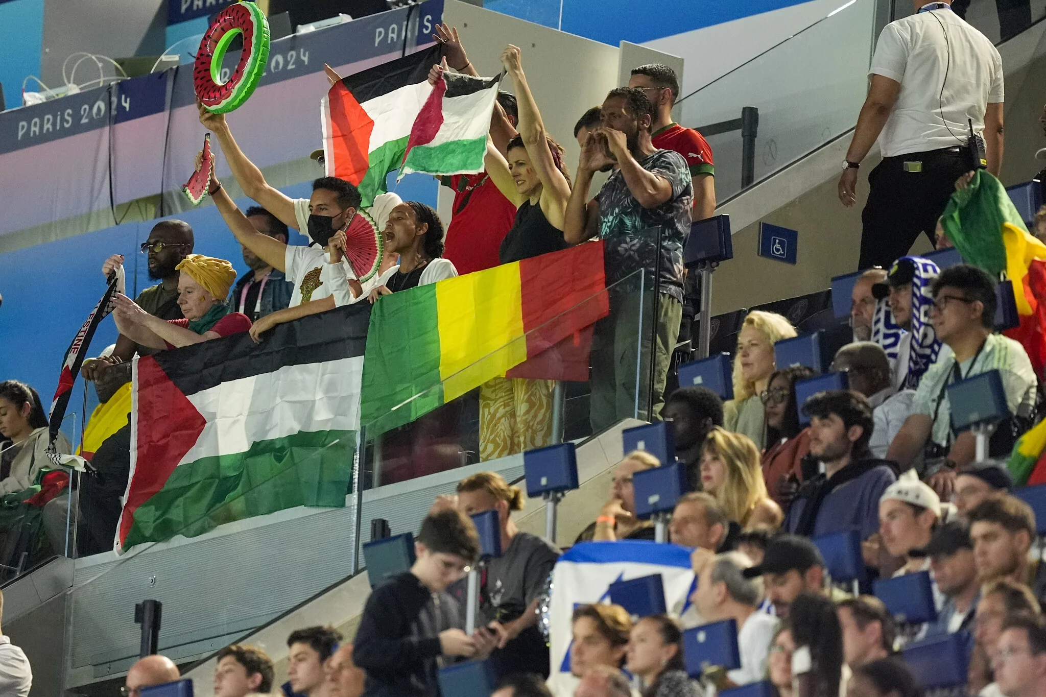 Banderas palestinas se ven entre los aficionados que miran el partido del grupo D masculino entre Israel y Mali en el Parque de los Príncipes durante los Juegos Olímpicos de Verano de 2024, el 24 de julio de 2024, en París, Francia. (Foto AP/Rebecca Blackwell)