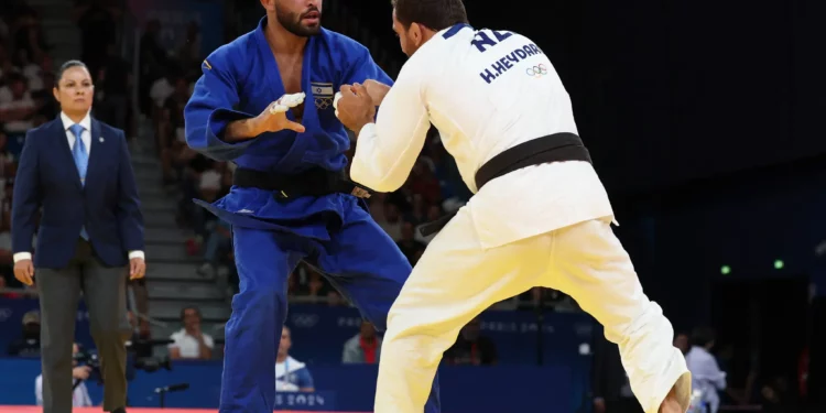 Hidayat Heydarov de Azerbaiyán y Tohar Butbul (azul) de Israel compiten en la ronda de 16 de judo masculino de -73 kg de los Juegos Olímpicos de París 2024 en el Champ-de-Mars Arena, en París, el 29 de julio de 2024. (Foto de Jack GUEZ / AFP)