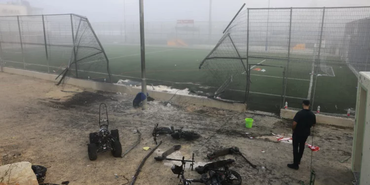 Un hombre se encuentra cerca de una puerta dañada después de un ataque con cohetes de Hezbolá en un campo de fútbol que mató a 12 niños en Majdal Shams el 28 de julio de 2024 (Menahem Kahana / AFP)