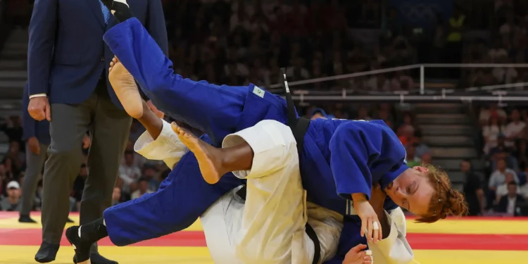 La francesa Marie Eve Gahie y la israelí Maya Goshen (azul) compiten en el combate de octavos de final de judo femenino de -70 kg de los Juegos Olímpicos de París 2024 en el Champ-de-Mars Arena, en París, el 31 de julio de 2024. (Jack GUEZ / AFP)