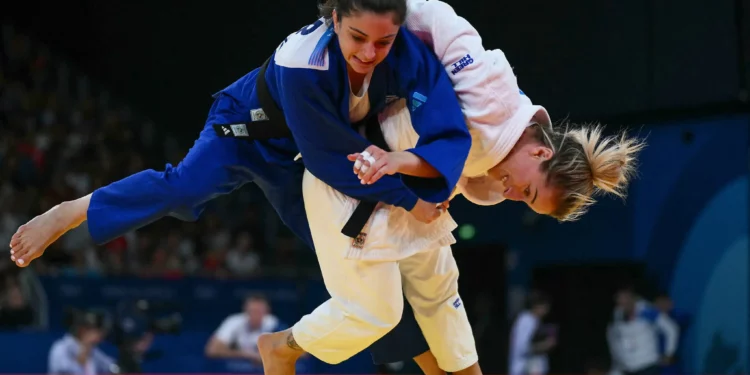 Distria Krasniqi de Kosovo y Gefen Primo de Israel (azul) compiten en el combate de cuartos de final de judo femenino de -52 kg de los Juegos Olímpicos de París 2024 en el Champ-de-Mars Arena, en París, el 28 de julio de 2024. (Luis ROBAYO / AFP)