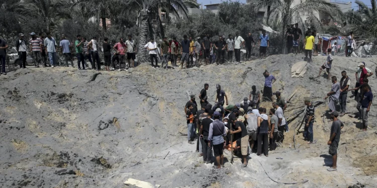 Palestinos inspeccionan los daños en un lugar afectado por una operación israelí dirigida contra el misterioso comandante militar de Hamás, Muhammad Deif, en Jan Yunis, en el sur de la Franja de Gaza, el 13 de julio de 2024. (Foto AP/Jehad Alshrafi)