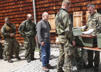 El canciller alemán Olaf Scholz hace fila para almorzar con soldados de montaña durante una visita de la brigada de infantería de montaña de las Fuerzas Armadas Federales Alemanas (Bundeswehr) en Schneizlreuth, sur de Alemania, el lunes 22 de julio de 2024. (Alexandra Beier/Pool Photo via AP)