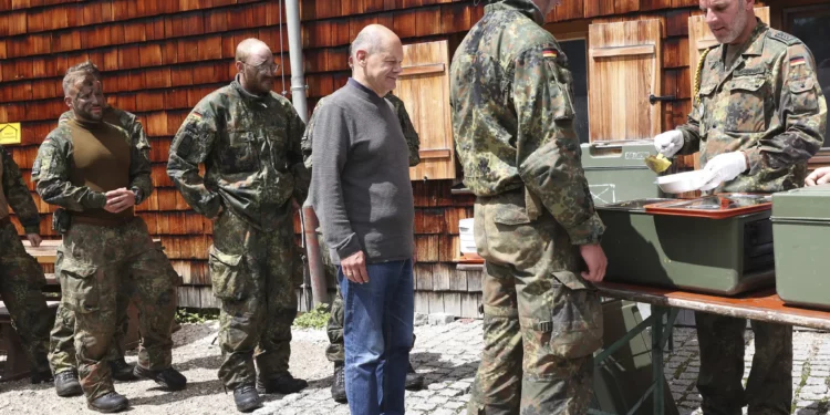 El canciller alemán Olaf Scholz hace fila para almorzar con soldados de montaña durante una visita de la brigada de infantería de montaña de las Fuerzas Armadas Federales Alemanas (Bundeswehr) en Schneizlreuth, sur de Alemania, el lunes 22 de julio de 2024. (Alexandra Beier/Pool Photo via AP)