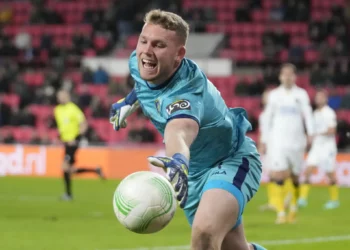 El portero del Maccabi Tel Aviv, Daniel Peretz, intenta mantener el balón dentro del área durante el partido de ida de los playoffs de la Conference League entre el PSV y el Maccabi Tel Aviv en el estadio Philips en Eindhoven, Países Bajos, el 17 de febrero de 2022. (Foto AP/Peter Dejong)