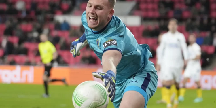 El portero del Maccabi Tel Aviv, Daniel Peretz, intenta mantener el balón dentro del área durante el partido de ida de los playoffs de la Conference League entre el PSV y el Maccabi Tel Aviv en el estadio Philips en Eindhoven, Países Bajos, el 17 de febrero de 2022. (Foto AP/Peter Dejong)