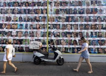 La gente pasa junto a carteles de israelíes tomados como rehenes por Hamás en Gaza desde el 7 de octubre, en Tel Aviv, el 11 de agosto de 2024. (Oren ZIV / AFP)