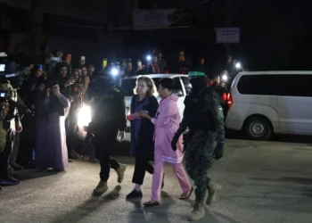 Terroristas de Hamás acompañan a rehenes israelíes recién liberados antes de entregarlos a la Cruz Roja en Rafah, en el sur de la Franja de Gaza, el 28 de noviembre de 2023. (SAID KHATIB / AFP)