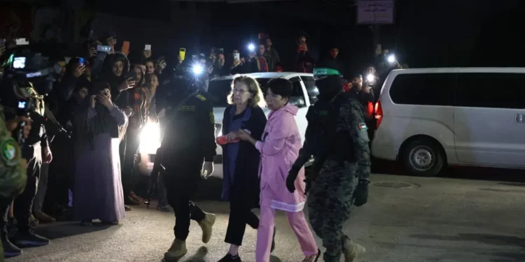 Terroristas de Hamás acompañan a rehenes israelíes recién liberados antes de entregarlos a la Cruz Roja en Rafah, en el sur de la Franja de Gaza, el 28 de noviembre de 2023. (SAID KHATIB / AFP)