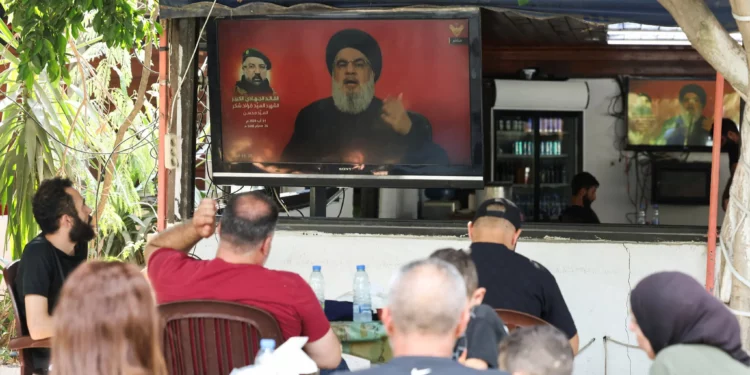 La gente mira una transmisión del discurso del líder del Hezbolá libanés, Hassan Nasrallah, sentados en un café en Tiro, en el sur del Líbano, el 1 de agosto de 2024. (Reuters/Aziz Taher)