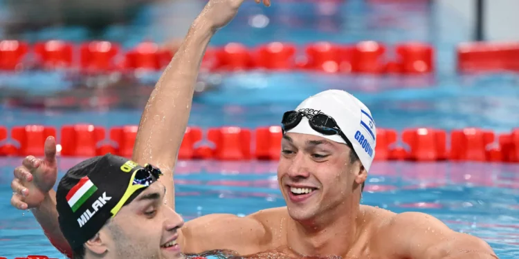 El húngaro Kristof Milak y el israelí Gal Cohen Groumi reaccionan después de una serie de los 100 m mariposa masculinos en los Juegos Olímpicos de París 2024 en el Arena París La Defense en Nanterre, al oeste de París, el 2 de agosto de 2024. (Jonathan Nackstrand/AFP)