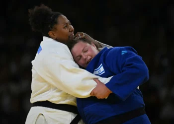 La brasileña Beatriz Souza y el israelí Raz Hershko (azul) se abrazan después de competir en la pelea por la medalla de oro de judo femenino +78 kg de los Juegos Olímpicos de París 2024 en el Champ-de-Mars Arena, en París el 2 de agosto de 2024. (Luis ROBAYO / AFP)