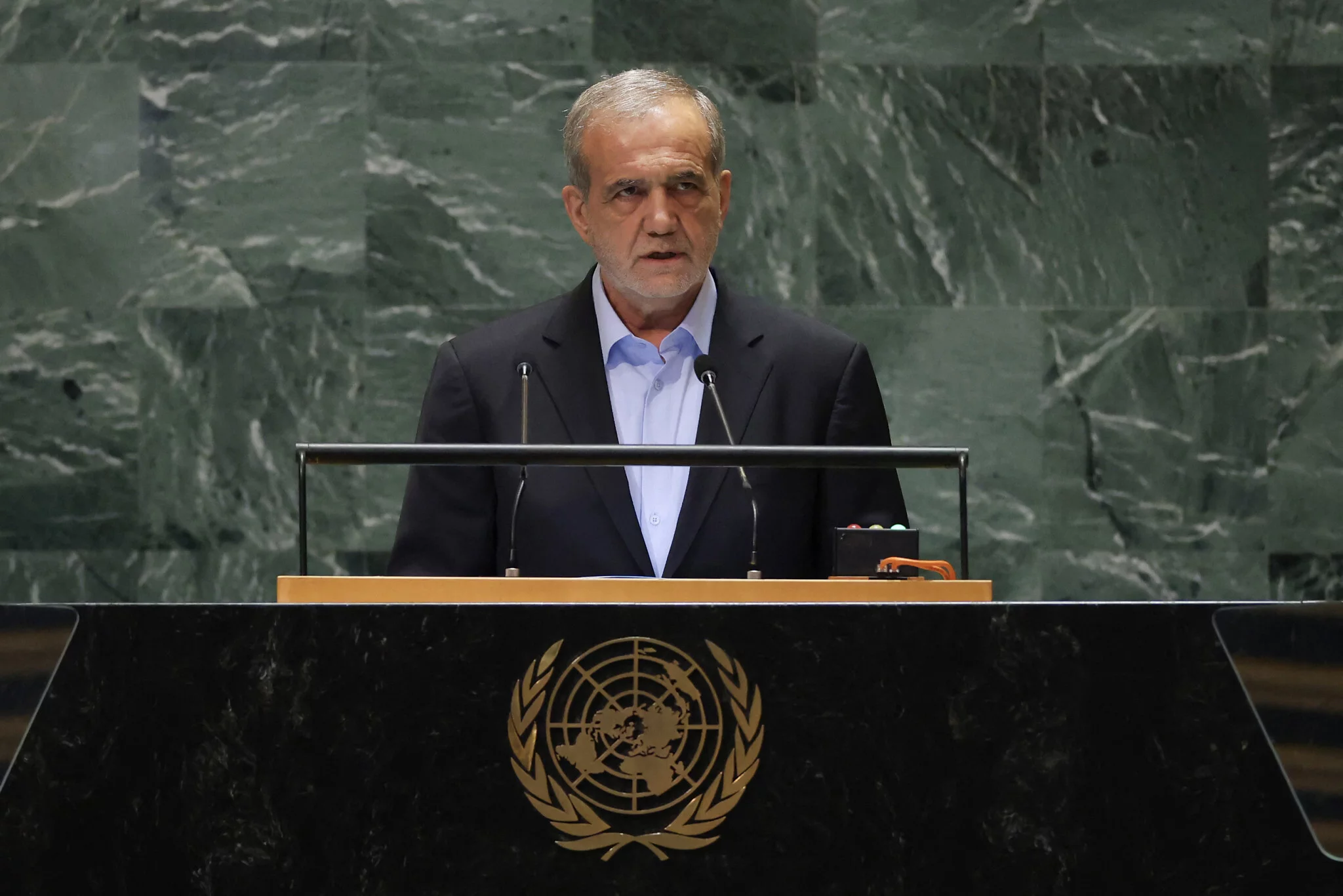 En su discurso ante la Asamblea general de la ONU, el presidente iraní Masoud Pezeshkian dice: “El mundo ha sido testigo de la verdadera naturaleza del régimen israelí” durante el último año de guerra en Gaza. “Ha sido testigo de cómo el régimen lleva a cabo atrocidades en Gaza y cómo en 11 meses ha asesinado a sangre fría a más de 41.000 personas inocentes, en su mayoría mujeres y niños”, afirma Pezeshkian, sin hacer distinción entre civiles y combatientes. “Sus líderes califican este genocidio –el asesinato de niños, los crímenes de guerra y el terrorismo de Estado– de legítima defensa. Califican a los hospitales, los jardines de infancia y las escuelas de objetivos militares legítimos. Califican de antisemitas a las personas valientes y amantes de la libertad de todo el mundo que protestan contra su genocidio. Califican de terroristas a las personas oprimidas que se han levantado contra siete décadas de ocupación y humillación”, continúa. “Es Israel el que ha asesinado a nuestros científicos, diplomáticos e incluso a nuestros invitados en nuestro territorio”, afirma el presidente iraní, aparentemente refiriéndose al líder de Hamás, Ismail Haniyeh, asesinado en Teherán en julio. Pezeshkian afirma, sin pruebas, que Israel “apoyó –tanto de forma encubierta como abierta– a grupos terroristas como el ISIS”. “Israel ha sido derrotado en Gaza y ninguna violencia bárbara puede restaurar su mito de invencibilidad”, afirma. Pide un alto el fuego en Gaza y “el fin de la barbarie desesperada de Israel en el Líbano antes de que se extienda a la región y al mundo”. El presidente iraní sostiene que la única solución al conflicto israelí-palestino es la celebración de un referéndum para los palestinos “que viven en su patria así como para aquellos que se han visto obligados a mudarse a su diáspora, para determinar su futuro”. “Estamos seguros de que a través de este mecanismo podemos lograr una paz duradera con musulmanes, cristianos y judíos viviendo juntos en una sola tierra en tranquilidad y paz”, dice Pezeshkian.