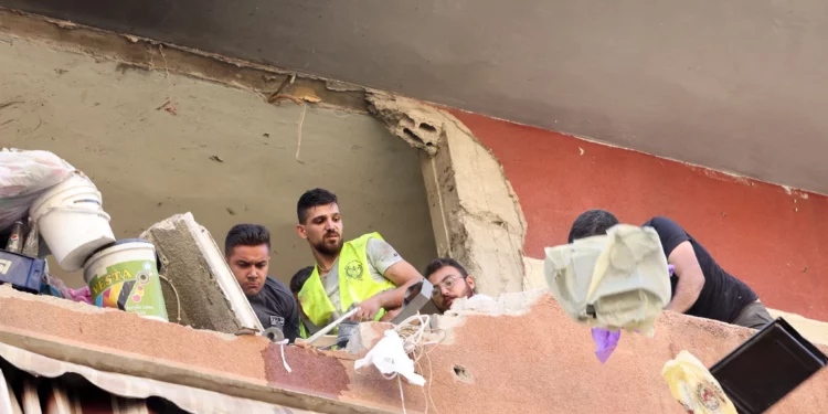 La gente retira los escombros de un edificio residencial cuyos dos pisos superiores fueron alcanzados por un ataque israelí contra la cabeza de la unidad de misiles de Hezbolá en el área de Ghobeiri, en los suburbios del sur de Beirut, el 24 de septiembre de 2024. (Foto de ANWAR AMRO / AFP)