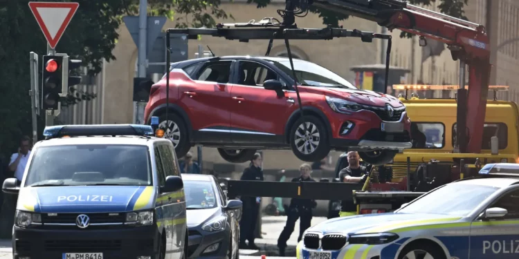 Los agentes de policía retiran con una grúa un coche con matrícula austriaca para asegurar la zona tras un tiroteo cerca del consulado israelí en Múnich el 5 de septiembre de 2024. (LUKAS BARTH-TUTTAS / AFP)