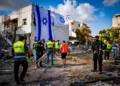 Trabajadores de rescate israelíes en el lugar donde un misil lanzado desde el Líbano impactó casas y automóviles en Kiryat Bialik, en el norte de Israel, el 22 de septiembre de 2024. (Chaim Goldberg/Flash90)