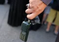 Un hombre sostiene un walkie-talkie después de quitarle la batería durante el funeral de las personas que murieron cuando cientos de dispositivos bíperes explotaron en un presunto ataque israelí contra Hezbolá en el Líbano el día anterior, en los suburbios del sur de Beirut el 18 de septiembre de 2024. (Anwar Amro/AFP)