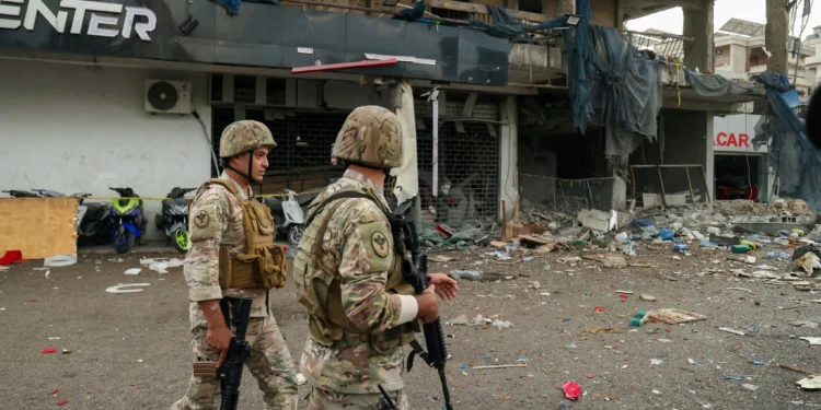 Soldados del ejército libanés aseguran el área afuera de un edificio que fue blanco de un ataque aéreo israelí contra Hezbolá en los suburbios del sur de Beirut el 2 de noviembre de 2024 (IBRAHIM AMRO / AFP)