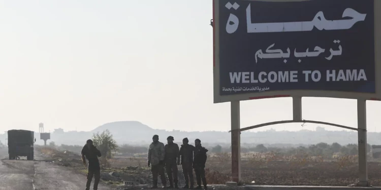 Combatientes de la oposición siria toman fotografías en las afueras de Hama, Siria, el 3 de diciembre de 2024. (Foto AP/Ghaith Alsayed)