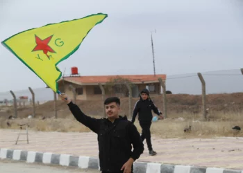 Un kurdo sirio ondea la bandera de las YPG (Unidades de Protección Popular) cerca del aeropuerto de Qamishli, en el noreste de Siria, el 8 de diciembre de 2024. (Delil SOULEIMAN / AFP)