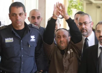 El jefe terrorista de Fatah, Marwan Barghouti, que cumple cinco cadenas perpetuas por asesinato durante la Segunda Intifada, es escoltado por la policía israelí hasta el Tribunal de Magistrados de Jerusalén para testificar como parte de una demanda civil estadounidense contra el liderazgo palestino, en enero de 2012. (Flash90)