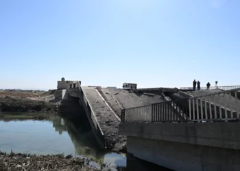 La gente inspecciona un puente supuestamente dañado en un ataque israelí cerca de la aldea siria de Tall al-Nabi Mando, en la zona rural de Qusayr, el 28 de octubre de 2024. (Louai Beshara / AFP)