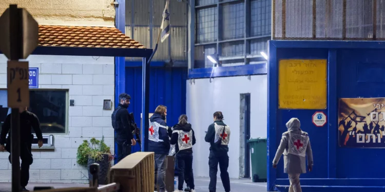 Miembros de la Cruz Roja a la entrada de la prisión de Ofer, en las afueras de Jerusalén, desde donde se iba a liberar a terroristas presos palestinos como parte de un acuerdo de rehenes entre Israel y Hamás, el 19 de enero de 2025. (Chaim Goldberg/Flash90)