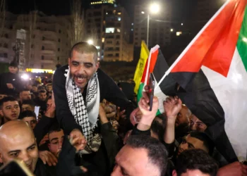 Zakaria Zubeidi, de 49 años, prisionero palestino y ex comandante de alto rango de las Brigadas de los Mártires de Al-Aqsa que fue liberado por Israel, ondea una bandera palestina mientras es vitoreado por la gente después de llegar a Ramallah a bordo de autobuses del Comité Internacional de la Cruz Roja (CICR), el 30 de enero de 2025. (AHMAD GHARABLI / AFP)