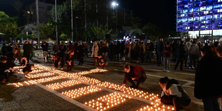 Familiares de israelíes tomados como rehenes por terroristas de Hamás y otras personas que piden la liberación de los rehenes encienden velas en memoria de los soldados israelíes muertos durante la guerra, en la octava noche de Janucá, en la plaza Rabin de Tel Aviv, el 1 de enero de 2025. (Tomer Neuberg/Flash90)