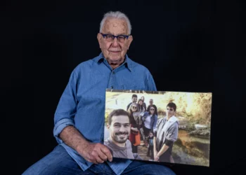 Naftali Furst, sobreviviente del Holocausto, sostiene una foto familiar tomada en Israel, mientras posa en su casa en la ciudad de Haifa, en el norte de Israel, el 28 de noviembre de 2024. (MENAHEM KAHANA / AFP)