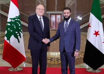 Una fotografía difundida por la agencia oficial de noticias árabe siria (SANA) muestra al primer ministro libanés, Najib Mikati (izq.), estrechando la mano del nuevo líder sirio, Ahmed al-Sharaa, antes de su reunión en Damasco el 11 de enero de 2025. (SANA/AFP)