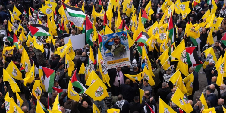 Palestinos sostienen banderas amarillas del movimiento Fatah mientras se manifiestan en apoyo a las fuerzas de seguridad palestinas en el campo de refugiados de Jenin, en el norte de Cisjordania, el 29 de diciembre de 2024. (Foto AP/Majdi Mohammed)