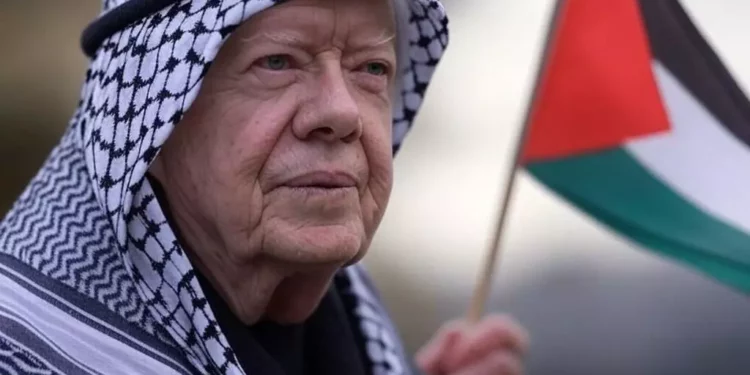 Jimmy Carter con kefiyeh y bandera palestina