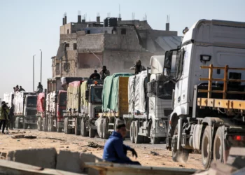 Un camarógrafo filma cómo los camiones que transportan ayuda humanitaria procedentes del cruce fronterizo de Kerem Shalom llegan a al-Shoka, al este de Rafah, en el sur de la Franja de Gaza, el 21 de enero de 2025. (Bashar TALEB / AFP)