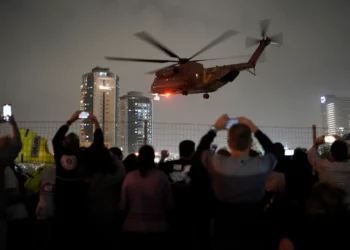 Archivo: Un grupo de israelíes observa cómo un helicóptero que transportaba rehenes liberados de la Franja de Gaza aterriza en el helipuerto del Centro Médico Infantil Schneider en Petah Tikva el 26 de noviembre de 2023 (AP/Leo Correa)