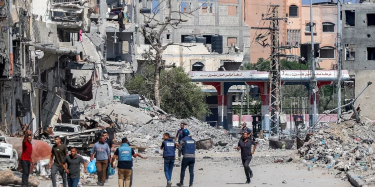 Periodistas filman frente a edificios destruidos en Jabaliya, en el norte de la Franja de Gaza, el 9 de octubre de 2024. (Omar Al-Qattaa/AFP)