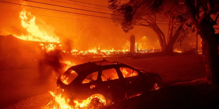 ARCHIVO - El incendio de Palisades quema vehículos y estructuras en el vecindario de Pacific Palisades en Los Ángeles, el 7 de enero de 2025. (Foto AP/Ethan Swope, Archivo)