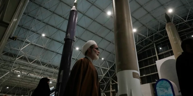 Un clérigo camina junto a misiles de fabricación nacional iraní mientras visita el Parque Aeroespacial Nacional de la Guardia Revolucionaria, en las afueras de Teherán, Irán, el 15 de noviembre de 2024. (Foto AP/Vahid Salemi)