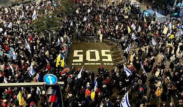 Manifestantes que exigen la liberación de todos los rehenes de Gaza se manifiestan con un escrito que destaca los 505 días que llevan en cautiverio, en la Puerta de Begin en Tel Aviv, el 22 de febrero de 2025. (Yael Gadot/Movimiento de Protesta Pro-Democracia)