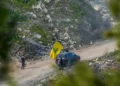 Libaneses ondean una bandera de Hezbolá en el sur del Líbano, vista desde el lado israelí de la frontera, el 18 de febrero de 2025 (Ayal Margolin/Flash90)