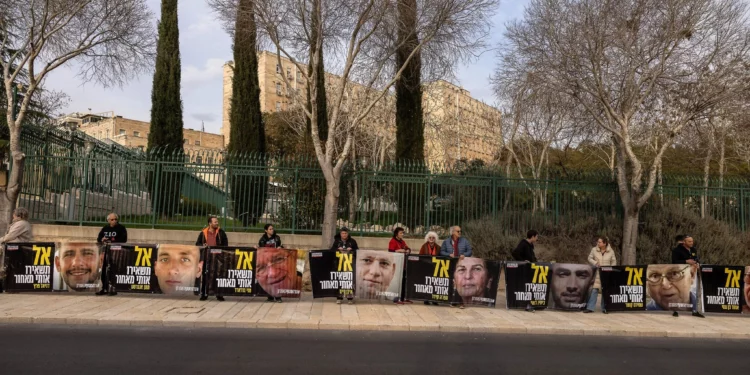 Partidarios y familiares de rehenes israelíes sostienen carteles con fotos de cautivos en los que se lee "No me dejen atrás", frente a la oficina del primer ministro en Jerusalén el 3 de febrero de 2025. (Menahem Kahana / AFP)