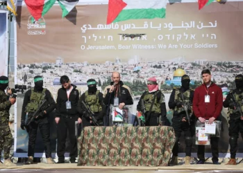 Rehenes de izquierda a derecha: Sagui Dekel-Chen, Iair Horn y Sasha Trupanov están en el escenario junto a hombres armados de Hamas y la Jihad Islámica durante su entrega a un equipo de la Cruz Roja en Khan Yunis, en el sur de la Franja de Gaza, el 15 de febrero de 2025 (Eyad BABA / AFP)