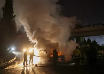 Los bomberos extinguen un vehículo de la FPNUL en llamas, provocado por manifestantes pro-Hezbolá, en la carretera que conduce al aeropuerto internacional de Beirut, el 14 de febrero de 2025. (Ibrahim Amro/AFP)