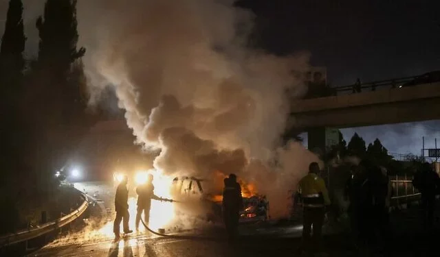 Los bomberos extinguen un vehículo de la FPNUL en llamas, provocado por manifestantes pro-Hezbolá, en la carretera que conduce al aeropuerto internacional de Beirut, el 14 de febrero de 2025. (Ibrahim Amro/AFP)