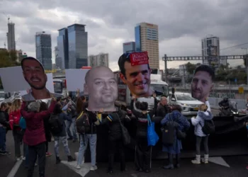 Familiares y simpatizantes de israelíes tomados como rehenes en la Franja de Gaza sostienen fotografías que muestran sus rostros durante una protesta para exigir su liberación del cautiverio de Hamás, en Tel Aviv, Israel, el jueves 13 de febrero de 2025. (AP/Oded Balilty)