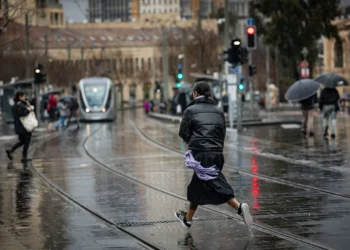 Personas caminando bajo la lluvia en la calle Jaffa, en Jerusalén, el 5 de febrero de 2025. (Yonatan Sindel/Flash90)