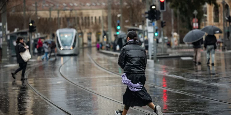 Personas caminando bajo la lluvia en la calle Jaffa, en Jerusalén, el 5 de febrero de 2025. (Yonatan Sindel/Flash90)