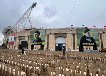 La gente pasa entre sillas instaladas en el exterior del estadio City Sportive de Beirut, un día antes de la procesión fúnebre de los líderes de Hezbolá Sayyed Hassan Nasrallah y Sayyed Hashem Safieddine, en Beirut, Líbano, el sábado 22 de febrero de 2025. (Foto AP/Hussein Malla)