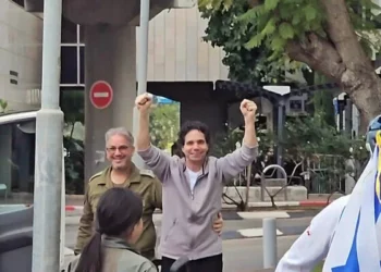 El rehén liberado Ofer Calderón levanta ambas manos y lanza besos a sus amigos afuera del Centro Médico Sheba a su regreso a Israel, el 1 de febrero de 2025 (Eyal Hadani/AFP)