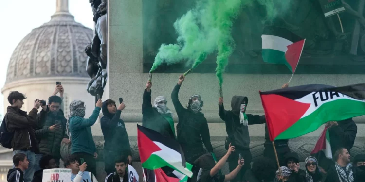 Manifestantes sostienen bengalas durante una manifestación pro palestina y antiisraelí en Londres, el 14 de octubre de 2023. (Foto AP/Kin Cheung)